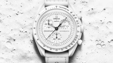 White Omega x Swatch Speedmaster MoonSwatch watch on textured surface, showing detailed design and chronograph functions.